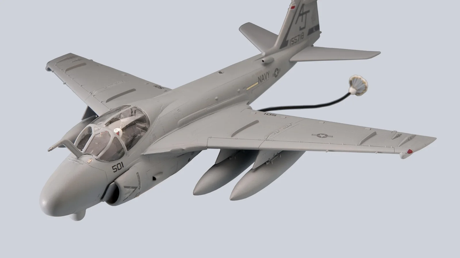 A finished grey model of a twin-engined naval attack jet on a plain pale ground, seen from above and to one side.